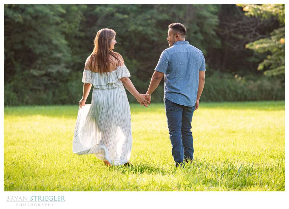 engagement photo walking through a field